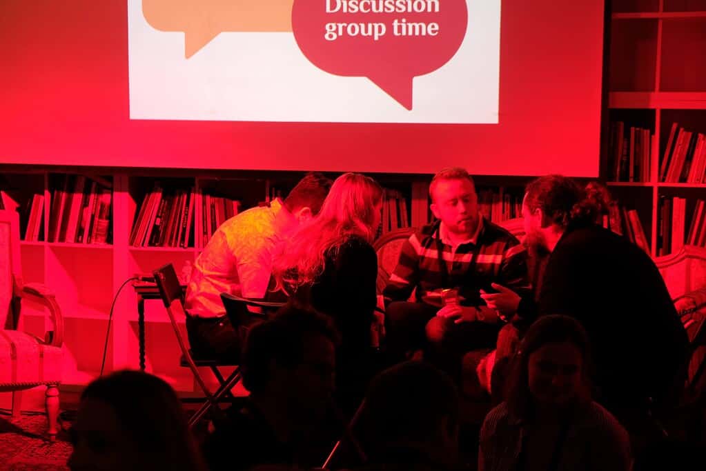 People engaged in a discussion group at the Coffeehouse Conference event.