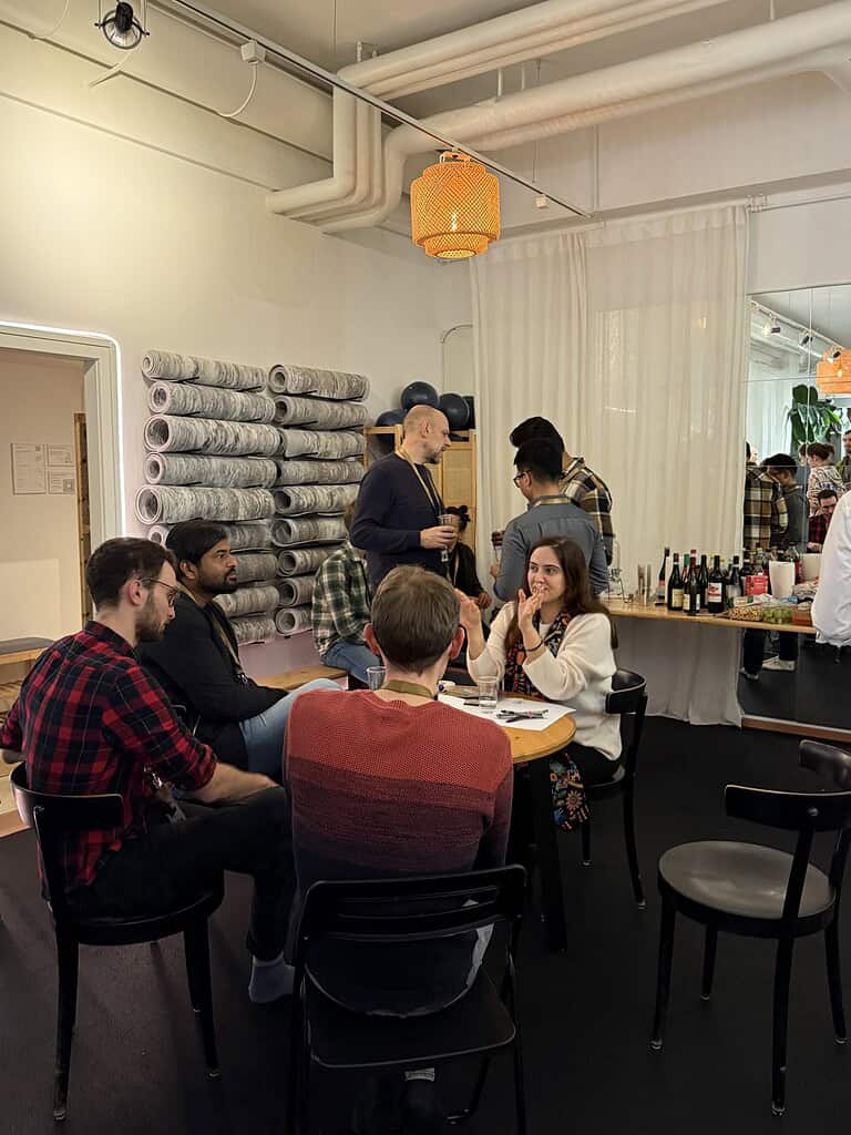Group of diverse people socializing and enjoying drinks at the Coffeehouse Conference event.