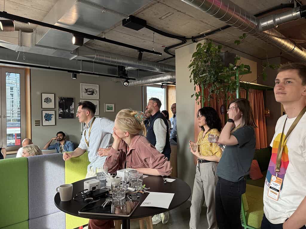 Diverse group of people attending a Coffeehouse Conference, listening and engaging in discussions in.
