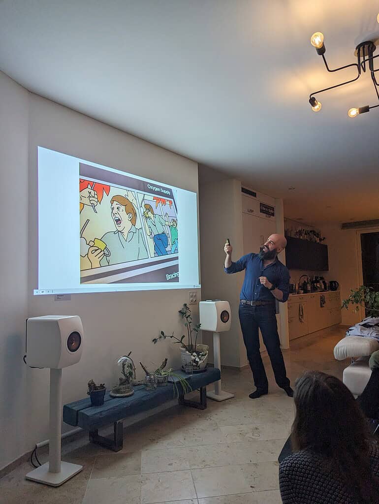Man giving a presentation at Coffeehouse Conference with a projected slide on the wall.
