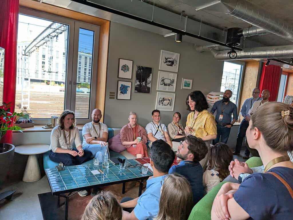 A woman speaking to an engaged audience during a Coffeehouse Conference event.