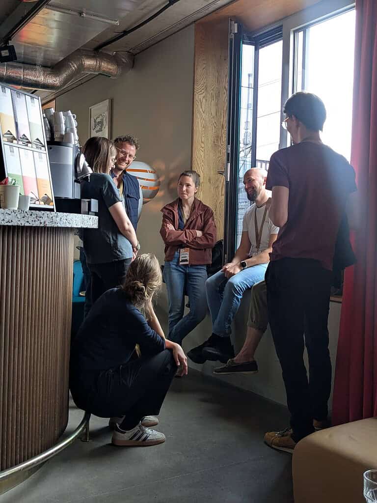Group of diverse people engaging in a lively discussion at Coffeehouse Conference.
