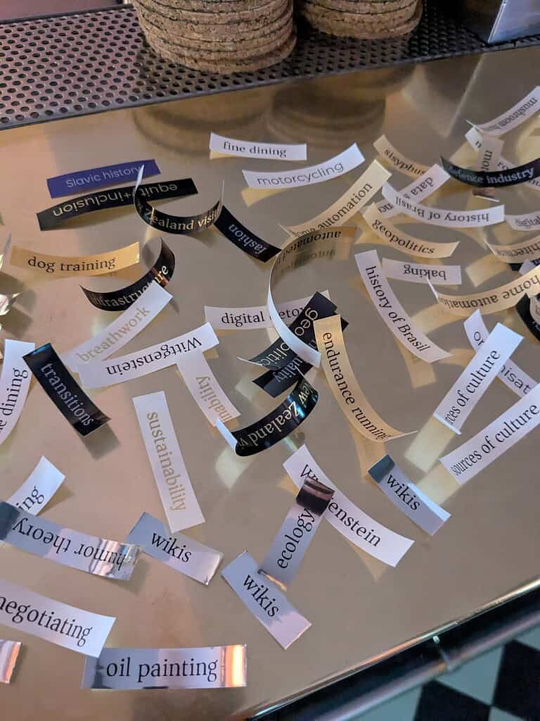 Collage of paper strips with words like sustainability, digital, endurance, and history of culture.