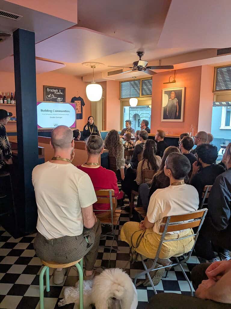 Attendees listening to a speaker during the Coffeehouse Conference event in a cozy, well-lit venue.